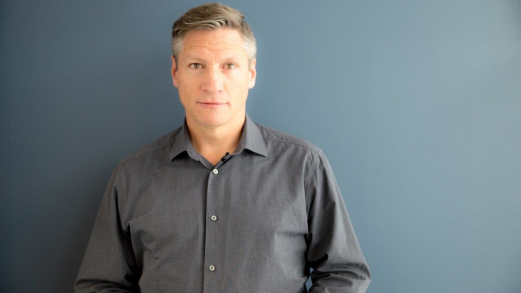 A person standing posing for the camera for an E-Learning video